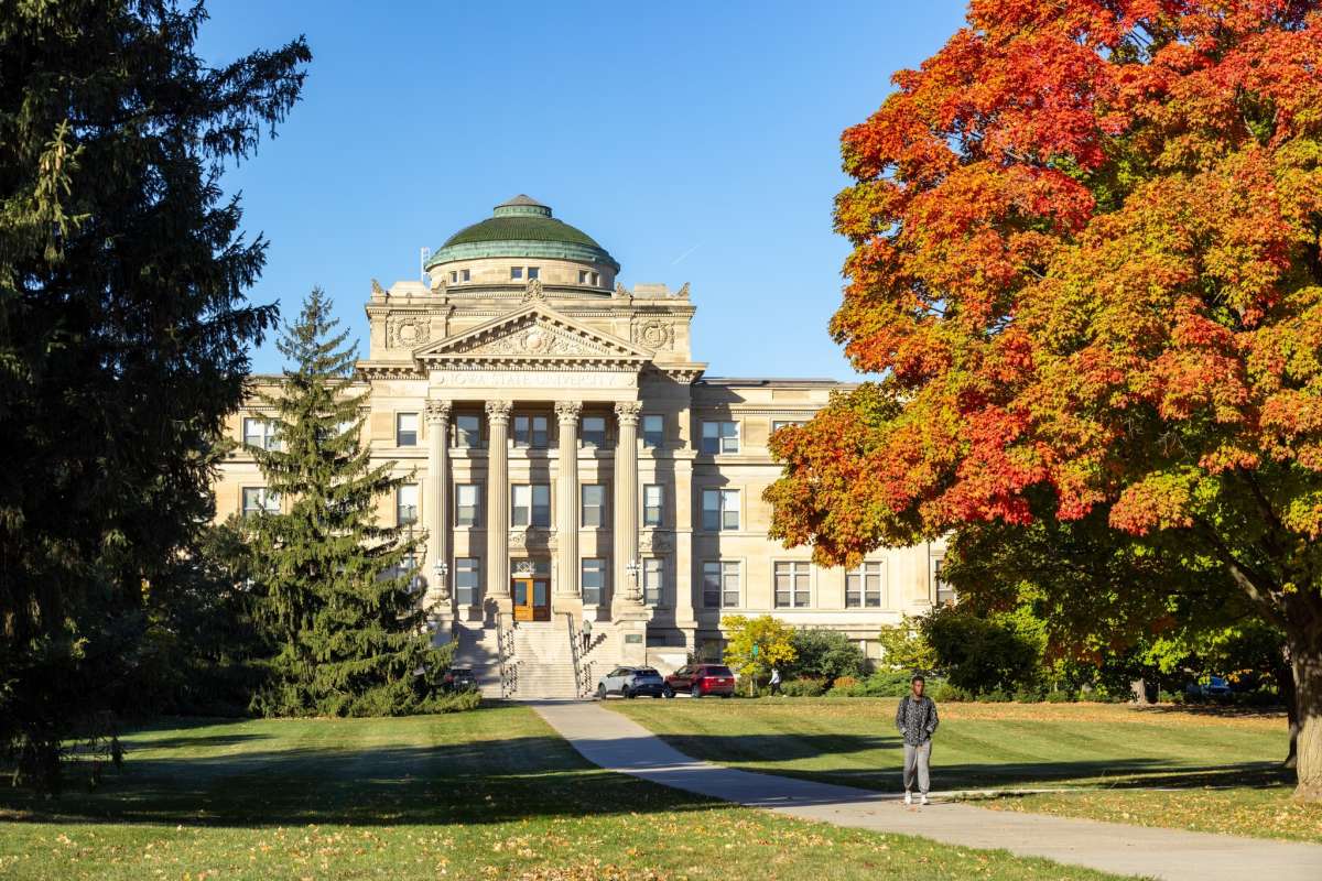 Beardshear Hall of Iowa State University Camps, with a clear blue sky in the background and autumn foliage in the foreground.